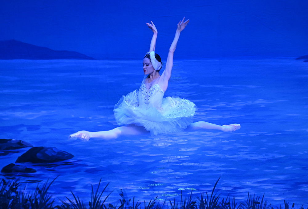 Balletttänzerinnen die springt auf der Bühne bei einem Tanz aus Schwanensee