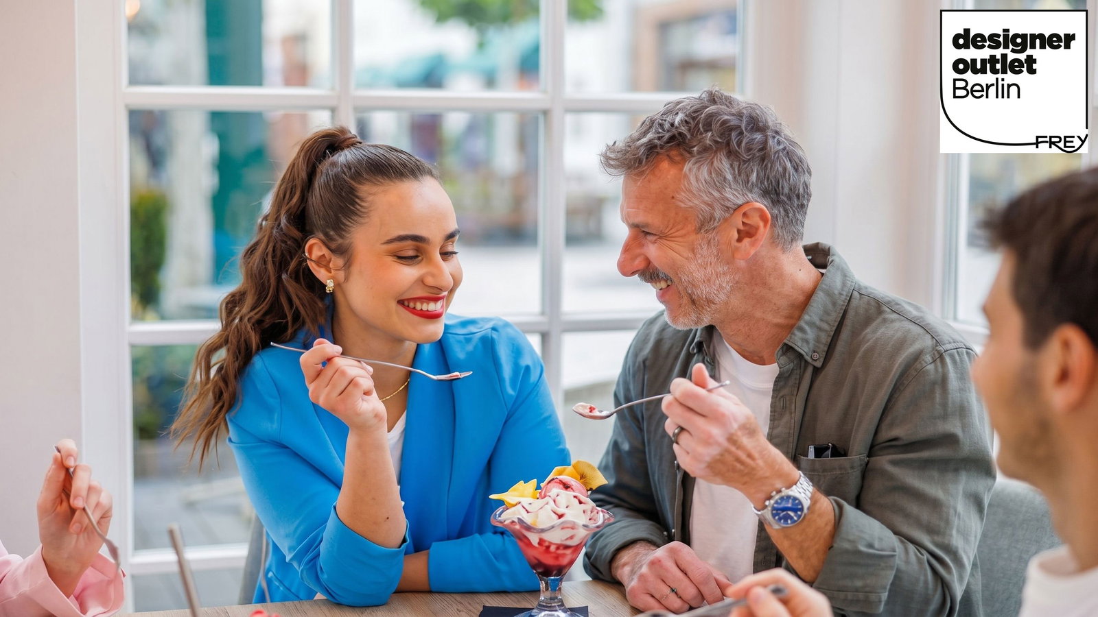 Mann und Frau teilen sich einen Eisbecher und freuen sich