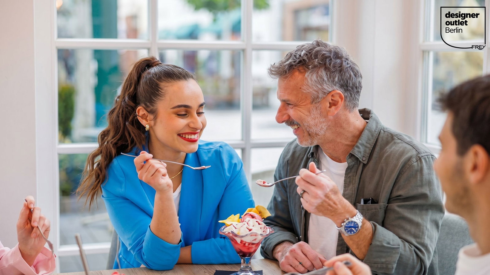 Mann und Frau teilen sich einen Eisbecher und freuen sich