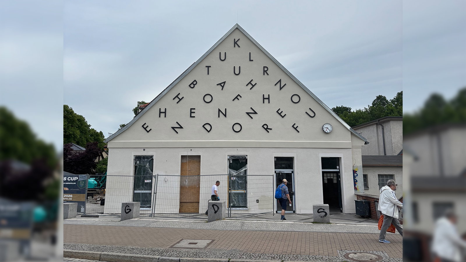 Ein Haus mit Spitzdach und vielen Buchstaben auf der Fassade